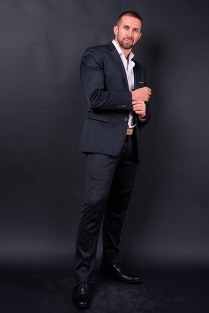 Photo full length portrait of a young man standing against wall