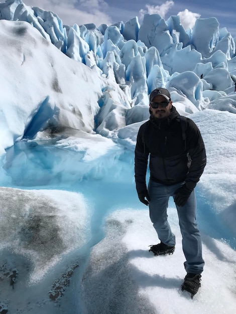 Full length portrait of young man standing on glacier