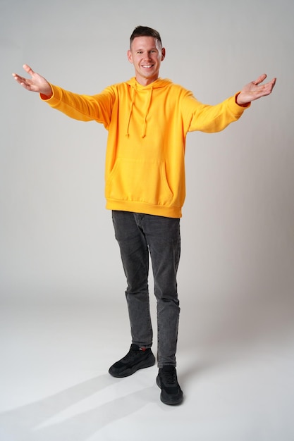 Photo full length portrait of young smiling man wearing casual clothes on gray background