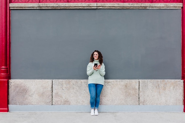 Photo full length portrait of young woman standing against wall