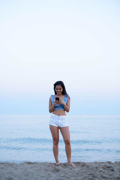 Full length portrait of young woman standing on beach