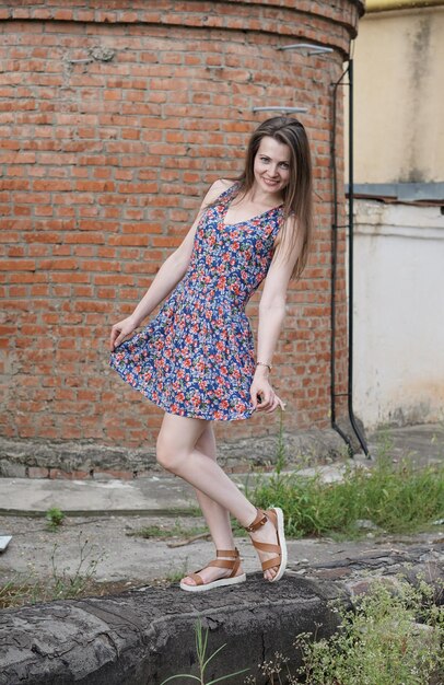 Photo full length portrait of young woman standing on wall