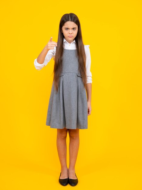 Full length of pretty cheerful teenager girl having fun good mood and posing in casual clothes isolated over yellow background