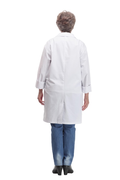 Full length profile studio shot of mature woman doctor in white coat and glasses walking