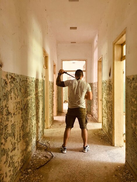 建物の中に立っている男の全長後ろの景色