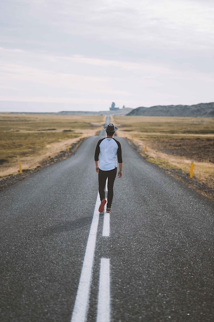 Photo full length rear view of man standing on road