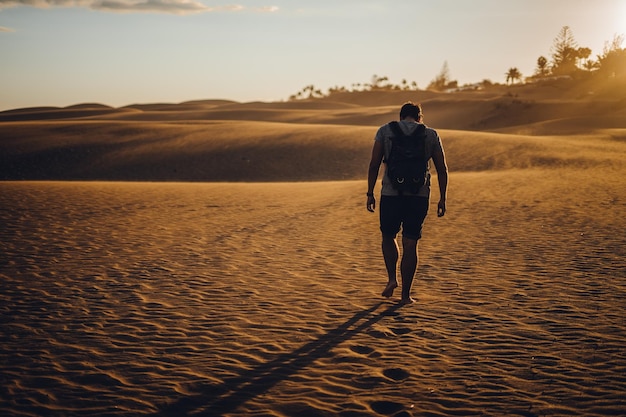 Photo full length rear view of man walking on desert