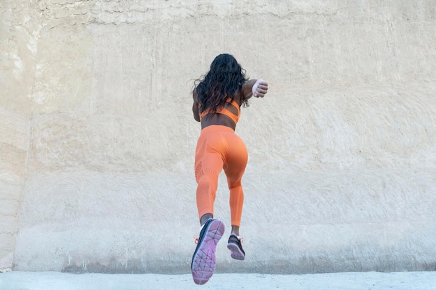 full length rear view of woman against wall