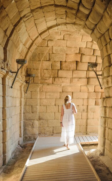 Full length rear view of woman standing against wall