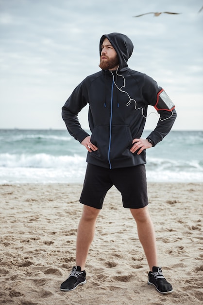 Full length runner on beach front view looking away