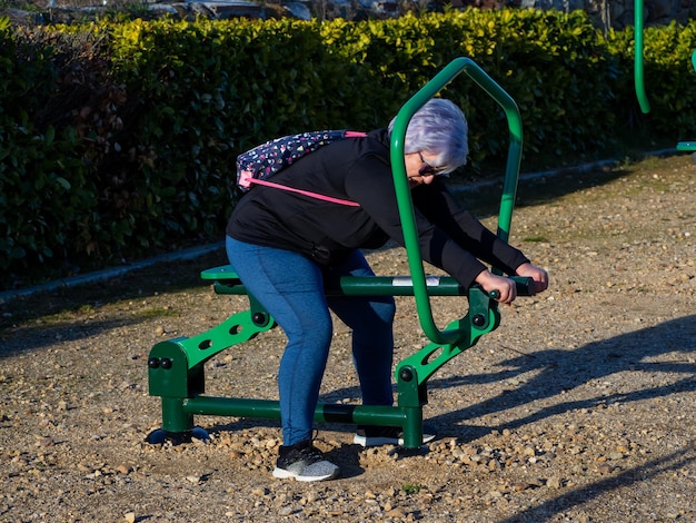 Foto lunghezza intera di una donna anziana che si esercita nel parco giochi