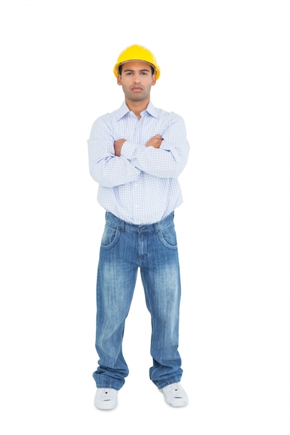 Full length of a serious handyman wearing a yellow hard hat