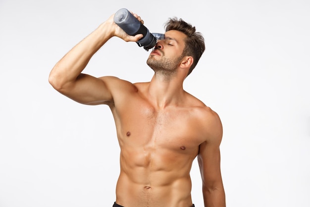 Full length of shirtless man against white background