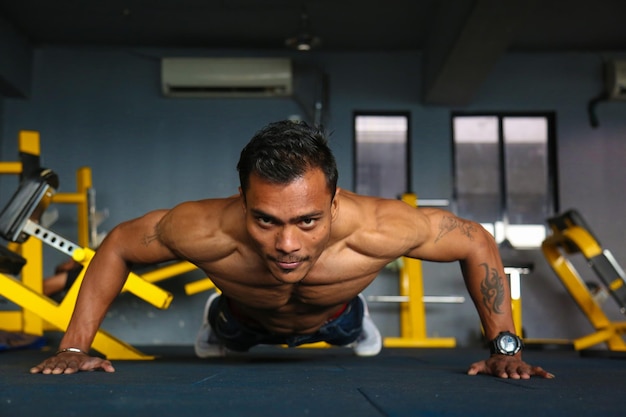 Full length of shirtless man exercising at home