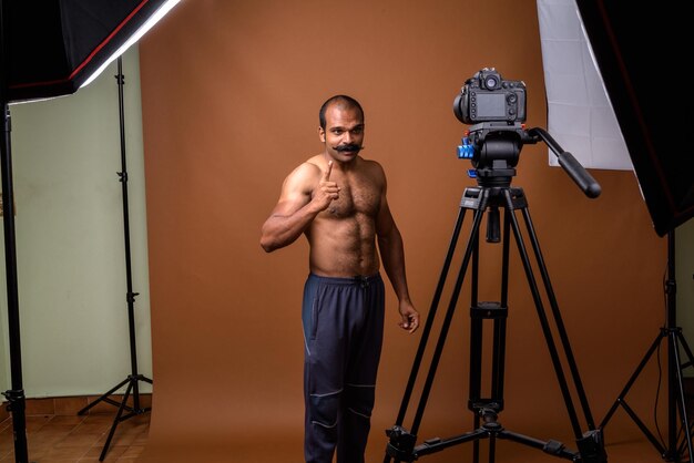 Full length of shirtless man photographing