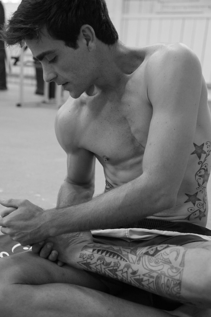 Photo full length of shirtless man sitting at home