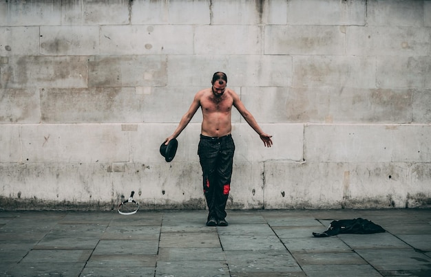 Photo full length of shirtless man standing against wall