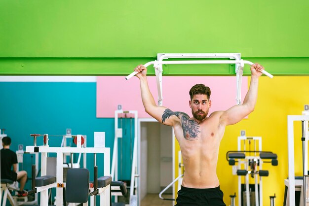 Full length of shirtless man standing against wall