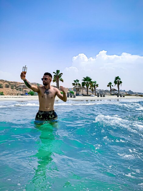 Full length of shirtless man standing in swimming pool