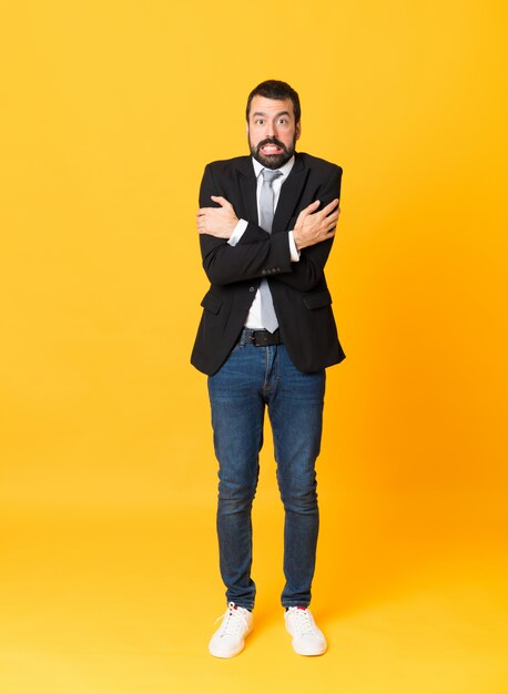 Full-length shot of business man over isolated yellow  freezing