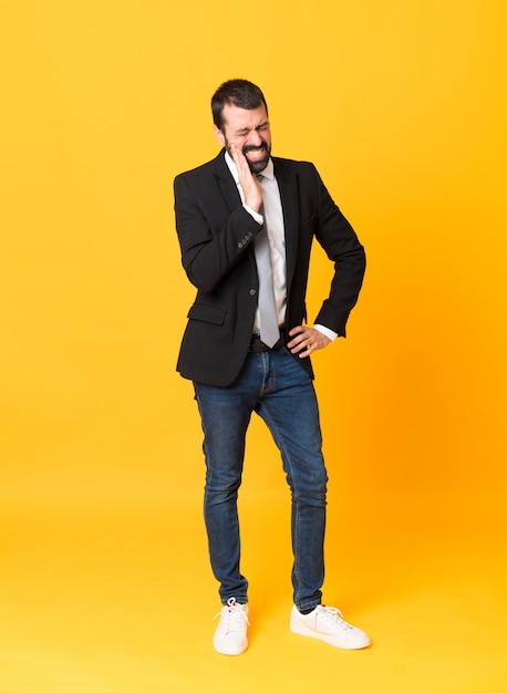 Full-length shot of business man over isolated yellow with toothache