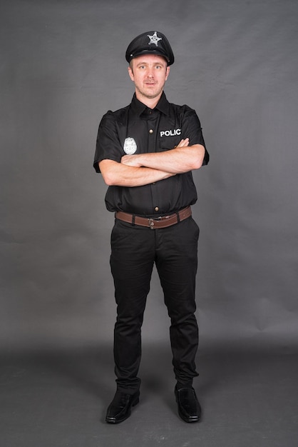 Full length shot of Caucasian man wearing police uniform costume