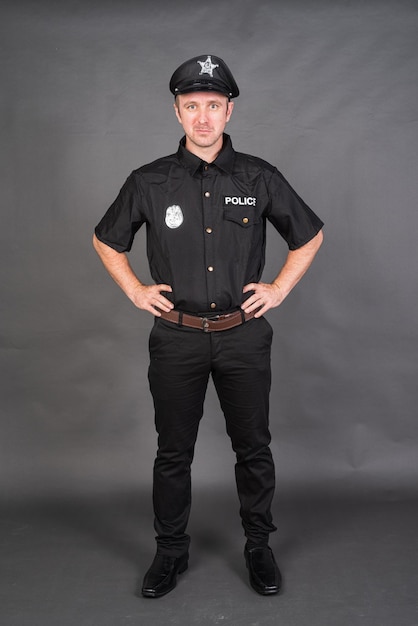 Full length shot of Caucasian man wearing police uniform costume