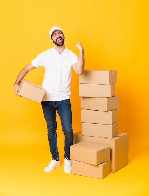 Full-length shot of delivery man among boxes celebrating a victory