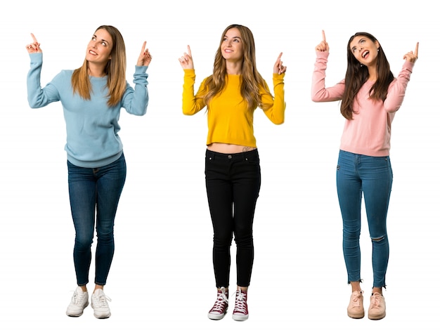 A full-length shot of a group of people with colorful clothes pointing with the index finger