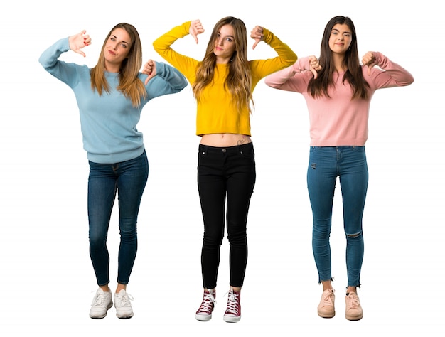 A full-length shot of a group of people with colorful clothes showing thumb down