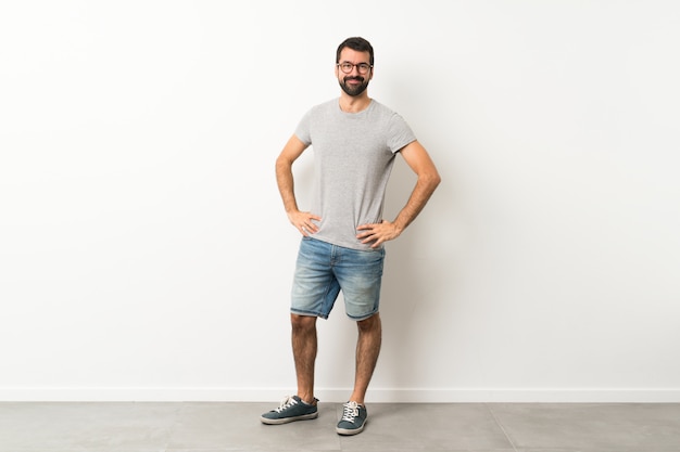 A full-length shot of handsome man with beard with glasses and smiling