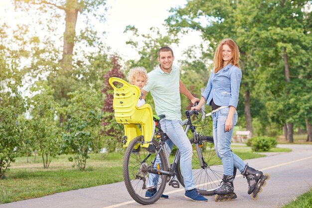 Full length shot of a happy young family enjoying cycling and rollerblading together at local park.