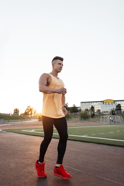 Full length shot of healthy young man running on the stadium Male runner sprinting outdoors