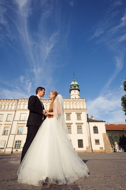  Full length shot of a just married couple holding hands on the city square