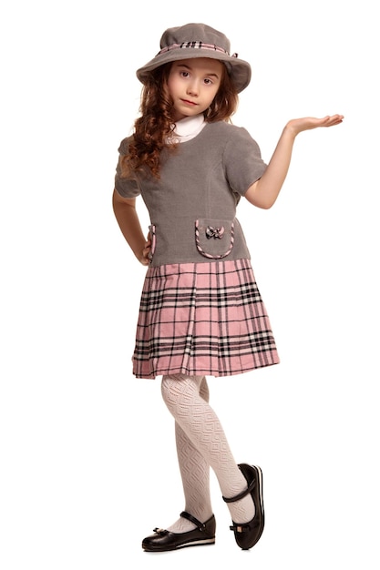 Full length shot of a lovely little kid with a long curly hair posing isolated on white background