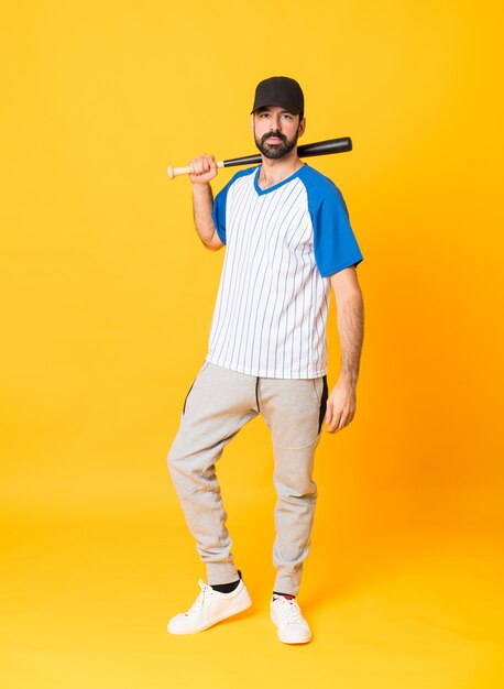 Full-length shot of man over isolated yellow playing baseball