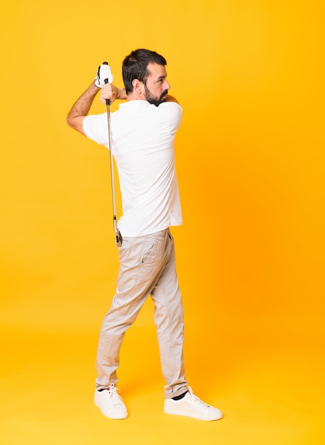 Full-length shot of man over yellow playing golf