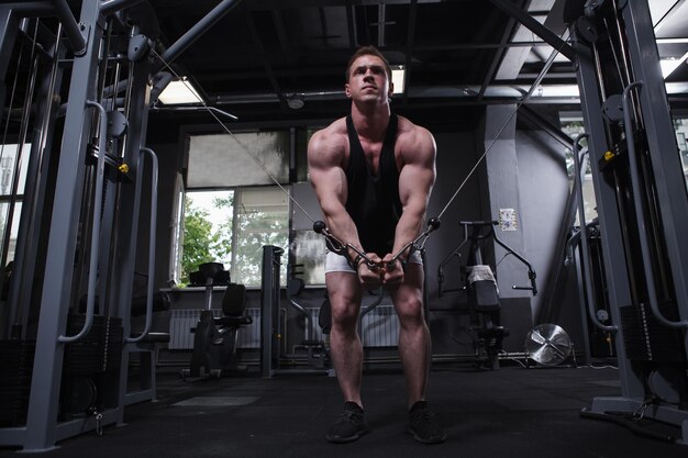 Photo full length shot of a muscular sportsman doing chest muscles workout at the gym