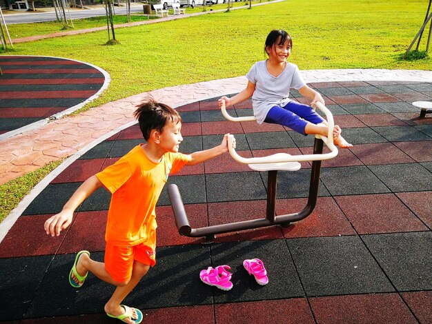 Full length of siblings playing at playground