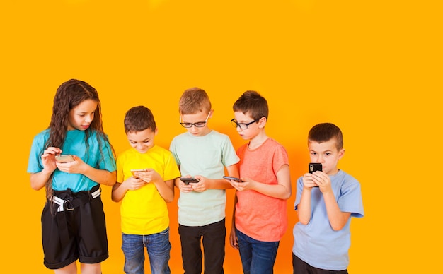 Full length of siblings standing against yellow background