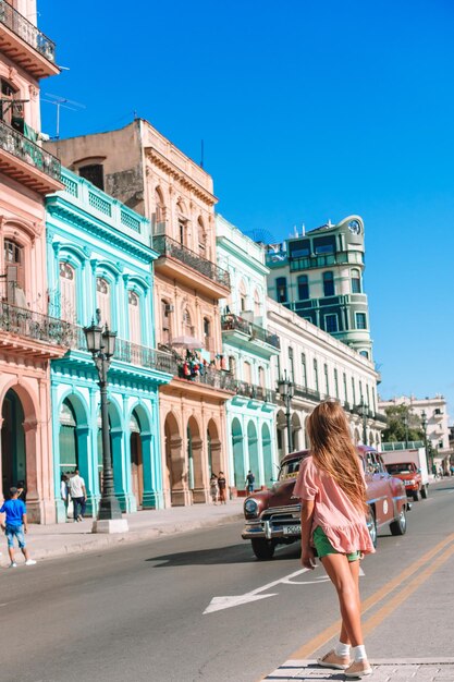 Full length side view of woman walking on road against buildings