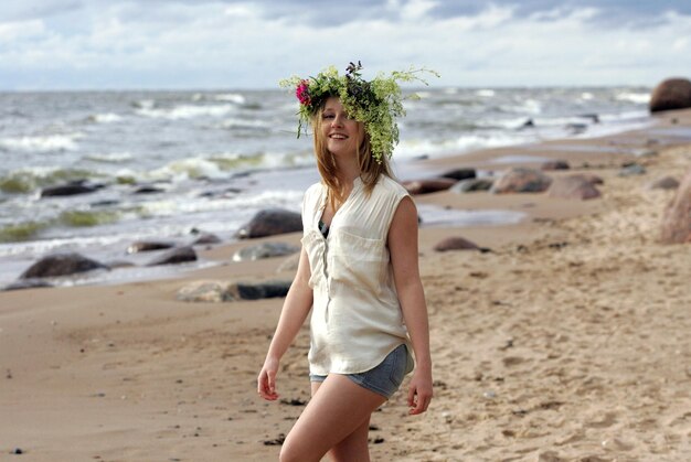 Photo full length of smiling young woman on beach