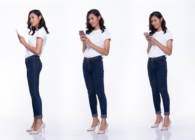 Полная длина Snap Figure, азиатская женщина носит повседневную белую рубашку, синие джинсы, ей 20 лет, она ходит во многих позах, пока болтает на смартфоне, студийное освещение на белом фоне, изолированная группа коллажей
