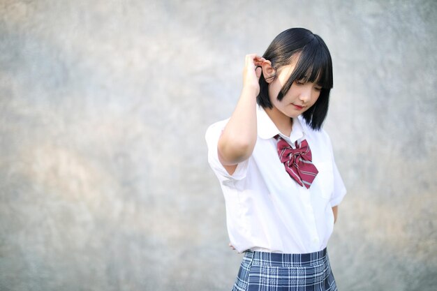 Photo full length of a teenage girl standing against wall