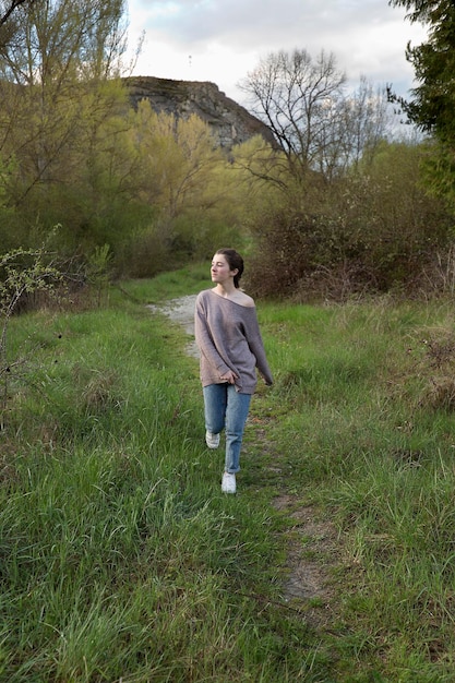 Foto lunghezza completa di una ragazza adolescente che cammina sul campo