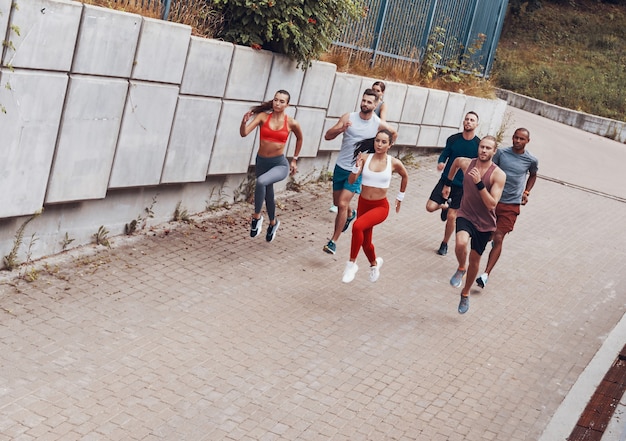 Foto vista dall'alto a tutta lunghezza dei giovani in abbigliamento sportivo che fanno jogging mentre si allenano all'aperto