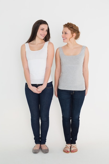 Photo full length of two casual young female friends