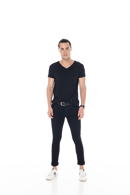 Full length view of brunette young man in black clothes isolated on white