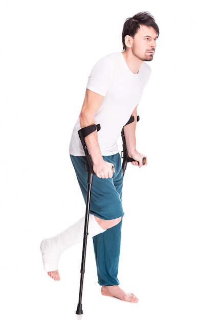 Photo full length view of a young man with broken leg.