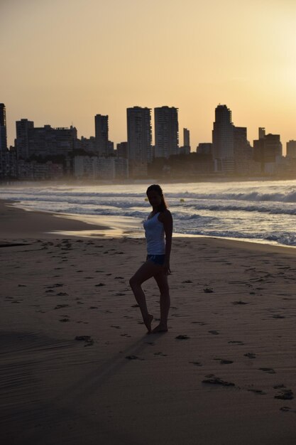 Photo full length of woman on beach against sky during sunset